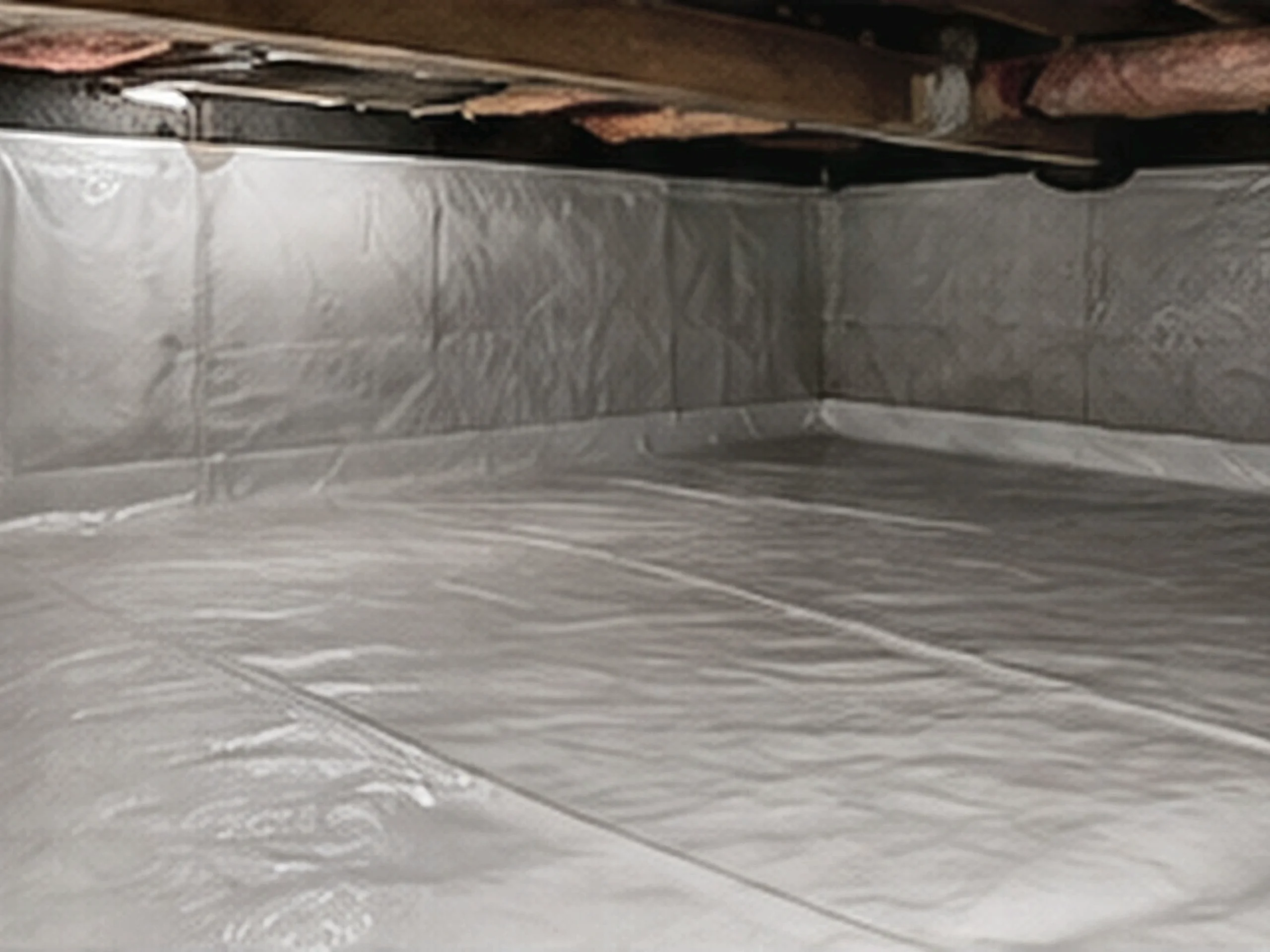 A heavy-duty vapor barrier installed in a residential crawl space
